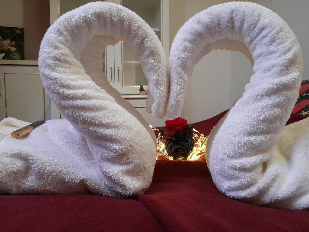 two towels shaped like hearts sitting on top of a bed at Béke Stúdió Apartman in Fonyód
