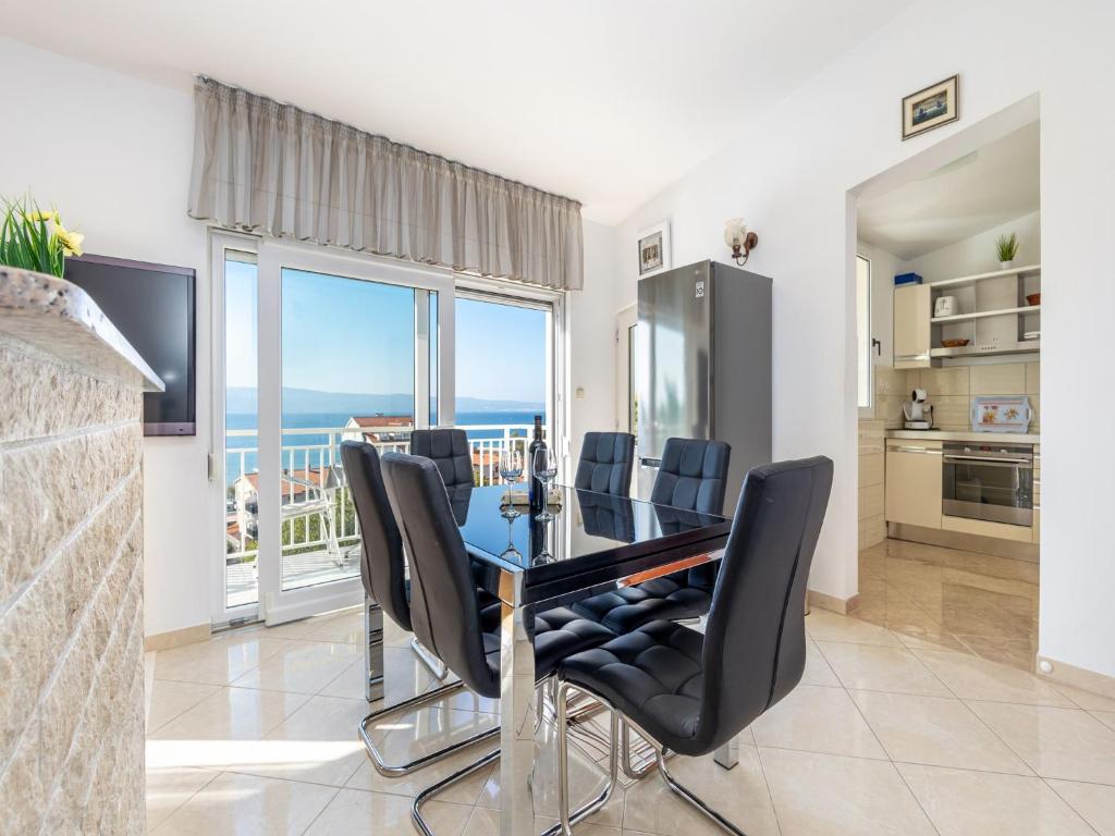 a dining room with a table and black chairs at Rosemary Apartments in Duće