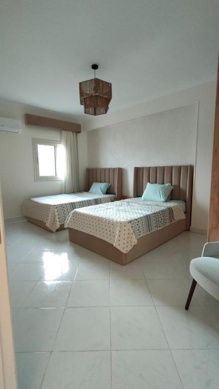 1 dormitorio con 2 camas y lámpara de araña en مدينة نصر en El Cairo