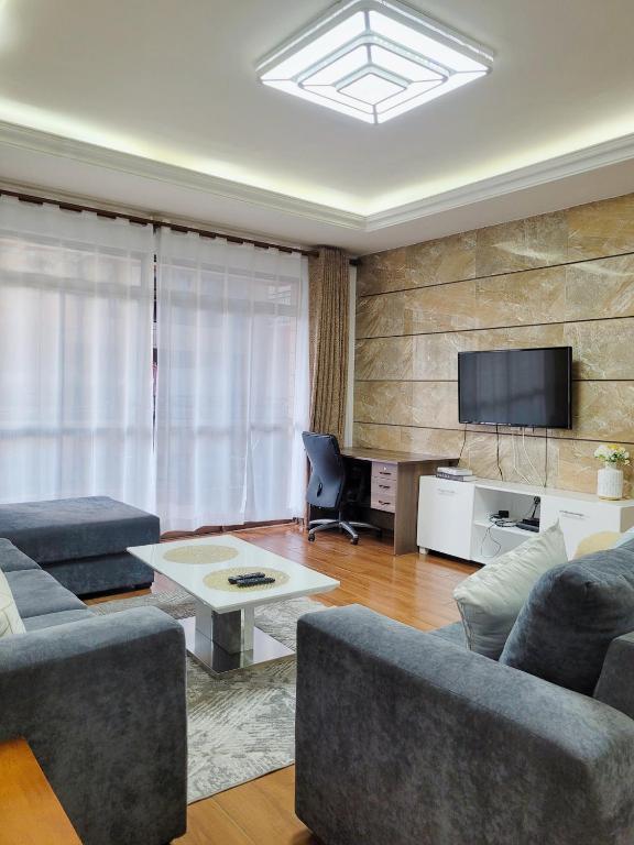 a living room with two couches and a tv at Stunning and serene homes in Nairobi