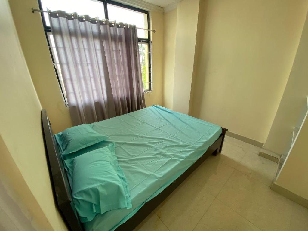 ハイデラバードにあるHOTEL PLAZA ROOMSの窓付きの部屋の病院用ベッド
