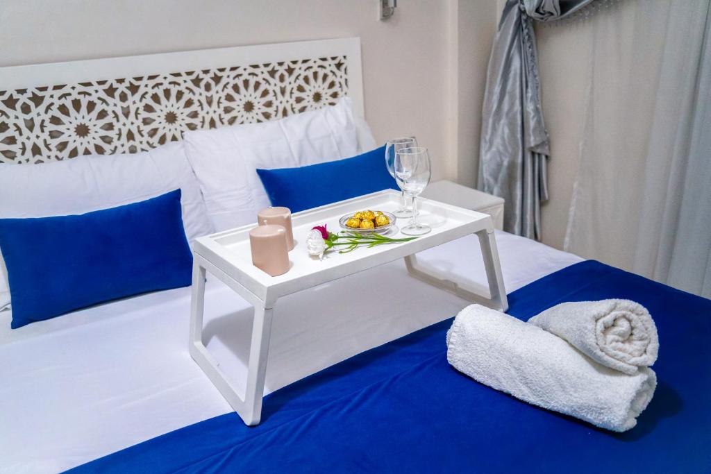 a white bed with a white table with a plate of fruit on it at Apartment for rent with 2 bedrooms in Tangier