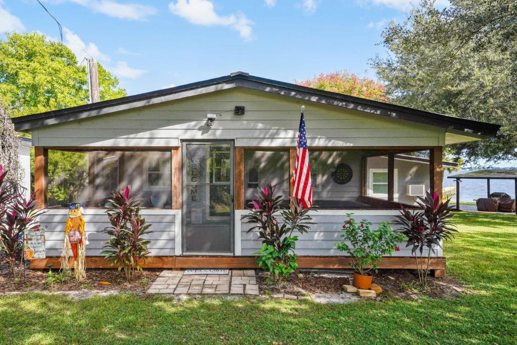 a small house with an american flag in front of it at Frostproof Lakefront Home with Screened-In Porches! in Frostproof