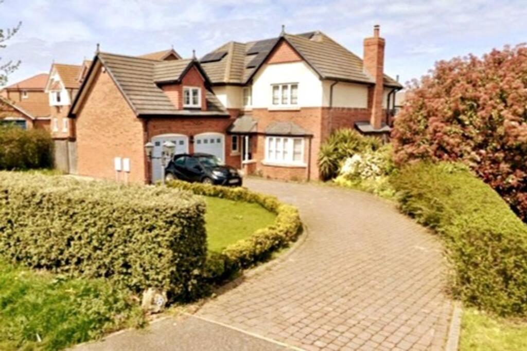 a brick house with a car parked in the driveway at Spacious 4 Bed Home, Eastchurch, Isle Of Sheppey in Eastchurch