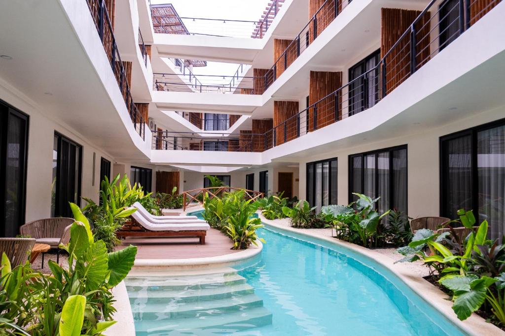 una piscina coperta in un hotel con sedie e piante di Santal Tulum a Tulum