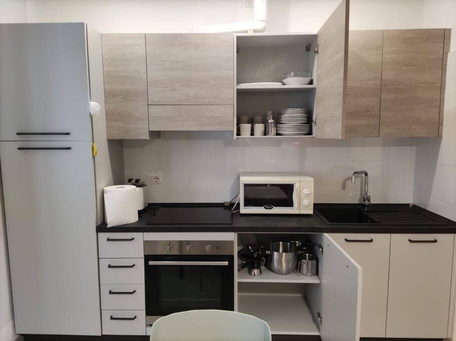 eine Küche mit weißen Schränken und einer weißen Mikrowelle in der Unterkunft Appartamento Le Rondini A in Intra