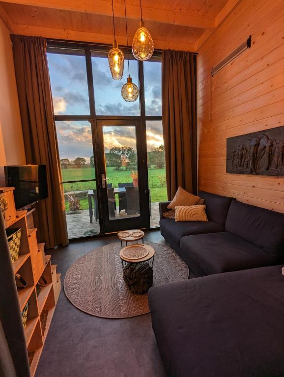 a living room with a couch and a large window at Klavertje 4 in Middelaar