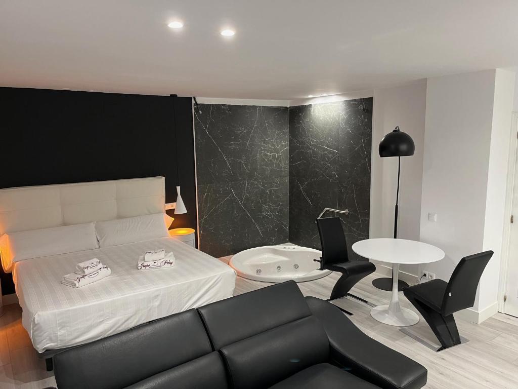 a living room with a bed and a table at H. Pelayo Autocheck-In Suites con Jacuzzi in Noja