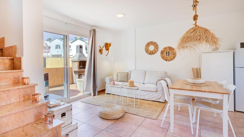 a living room with a white couch and a table at Palm Beach House in Corralejo