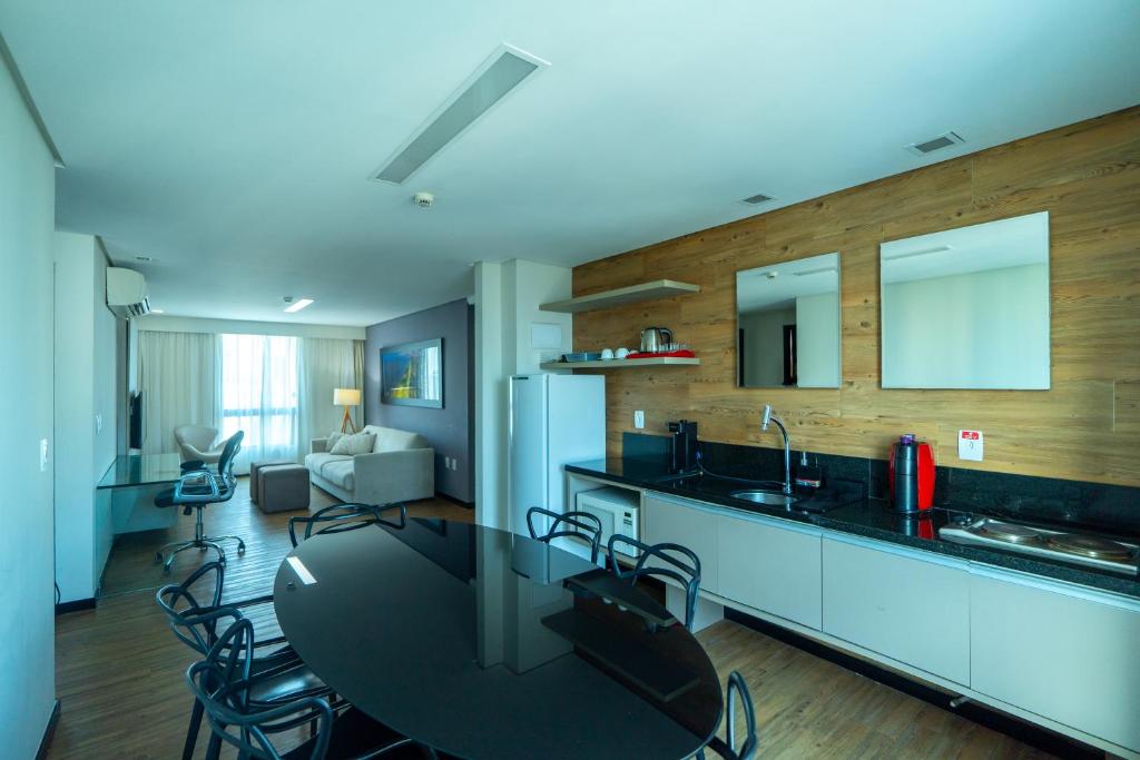 a kitchen with a black table and chairs in a room at Roomo Praia de Boa Viagem Residencial in Recife