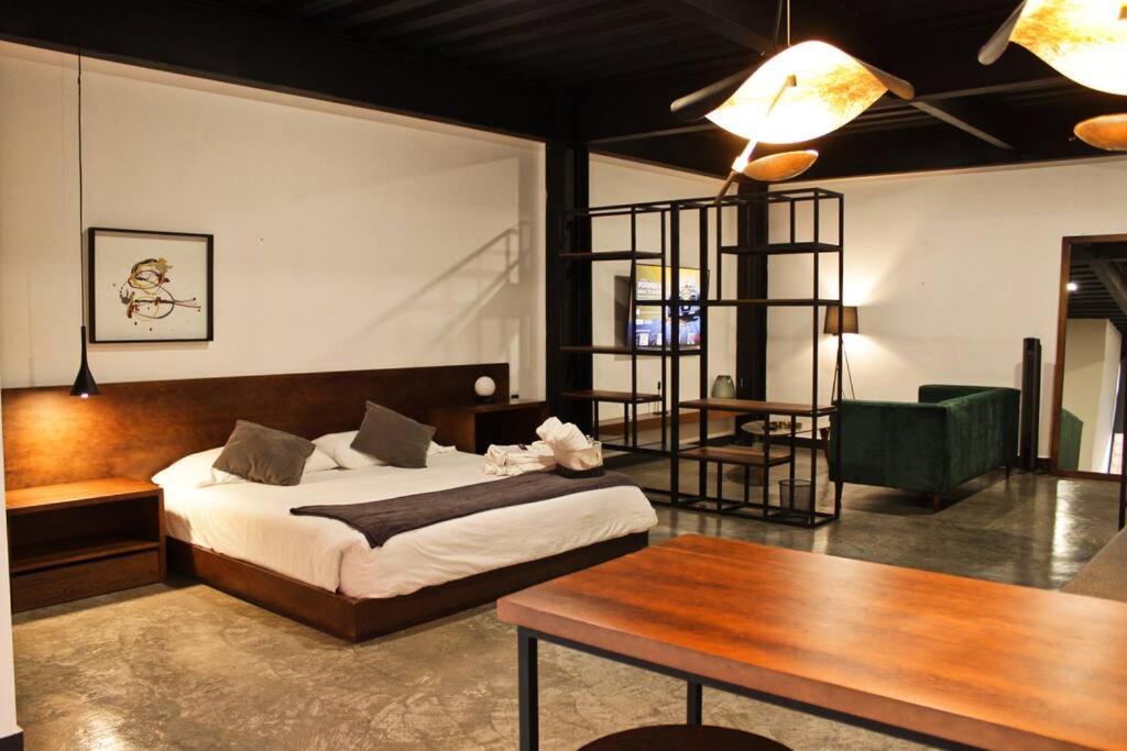 a bedroom with a bed and a wooden table and a table sidx sidx at Loft platino en excelente ubicación! in San Luis Potosí