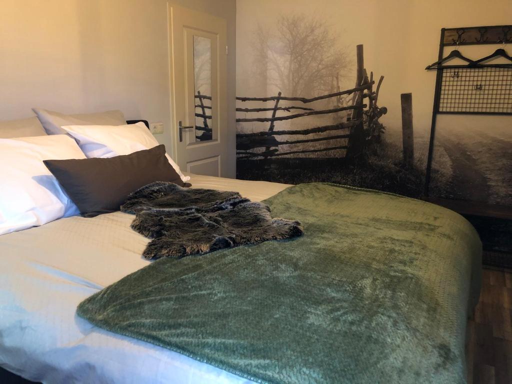 een bed met een groene deken erop bij B&B Typisch Lelies in Liessel