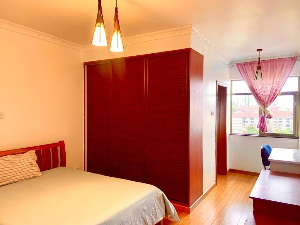 a bedroom with a bed and a desk and a window at Lavington Room1 in Nairobi