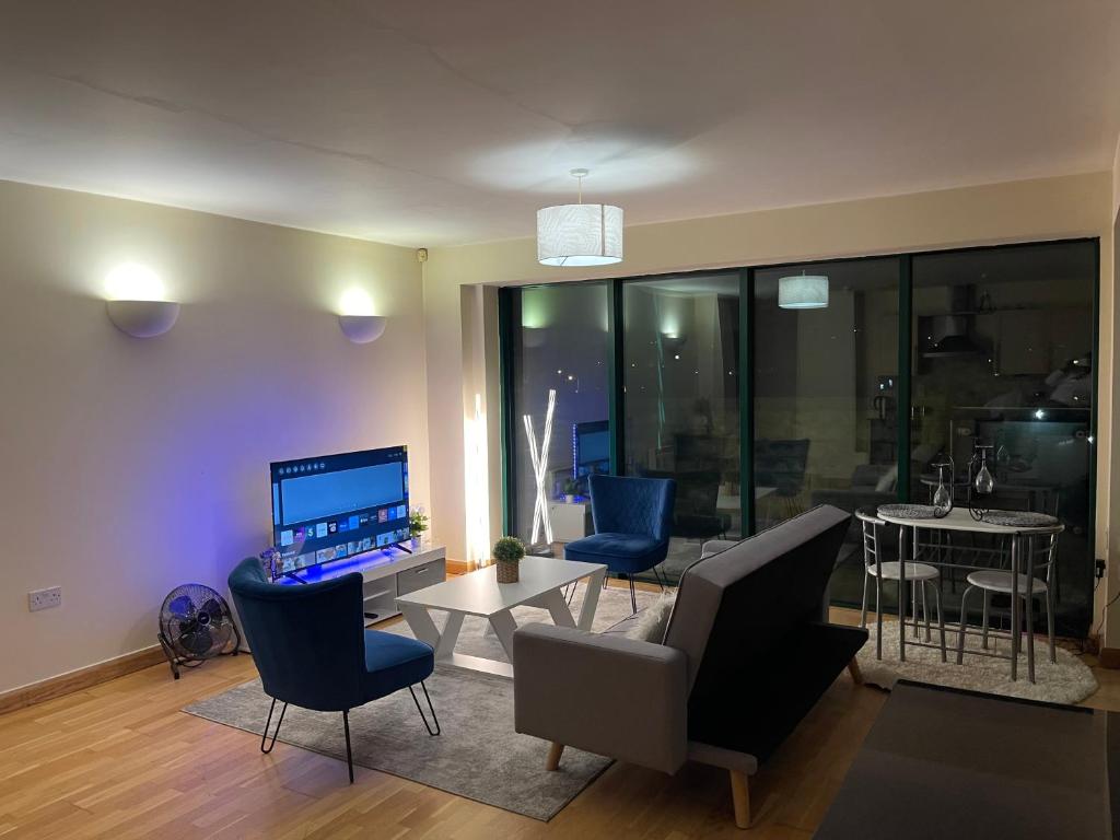 een woonkamer met een bank, stoelen en een tafel bij 2 Bedroom Stunning Penthouse city view in Bradford