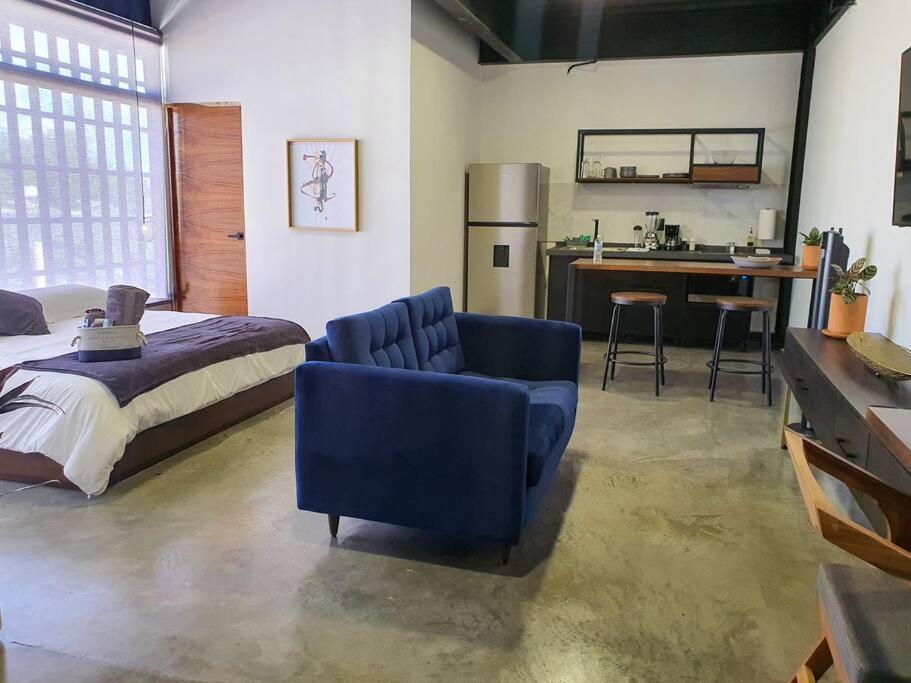 a bedroom with a bed and a blue chair at Loft plata en excelente ubicación in San Luis Potosí