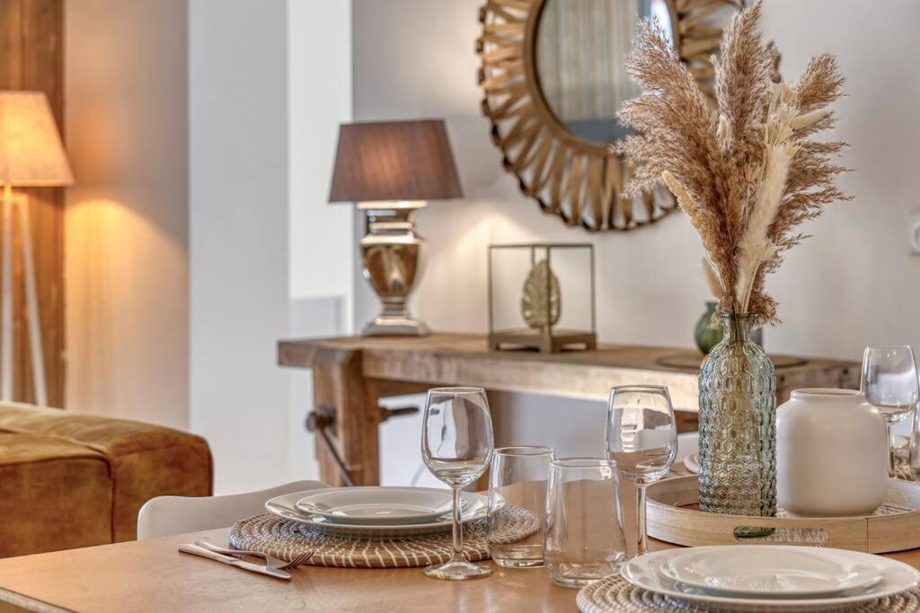 - une table à manger avec des verres et un miroir dans l'établissement Appartement «Chez Paulette»situé à 25Km chamonix , à Saint-Gervais-les-Bains