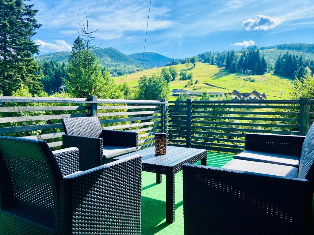 a patio with chairs and a table with a view at Villa Makuchówka in Korbielów