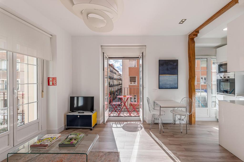 a living room with a television and a table at BNBHolder Charming & Stylish CHUECA in Madrid