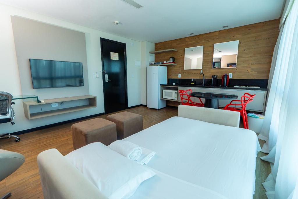 a living room with a white couch and a kitchen at Roomo Praia de Boa Viagem Residencial in Recife