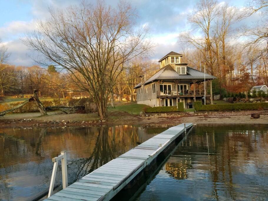 a large house on the water with a dock at Waterfront Home on Bantam Lake with Private Beach in Morris