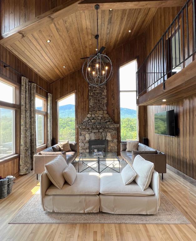 a living room with a couch and a stone fireplace at Spectacular Views, Private River Access Home in Wilmington