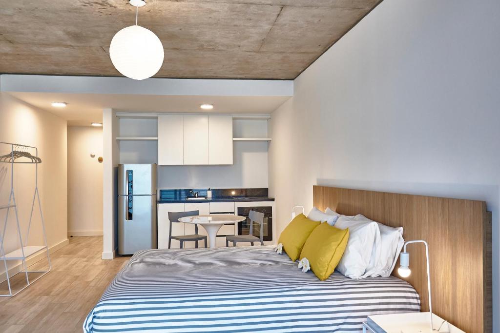 Un dormitorio con una cama grande con almohadas amarillas. en Babel Botánico, en Buenos Aires