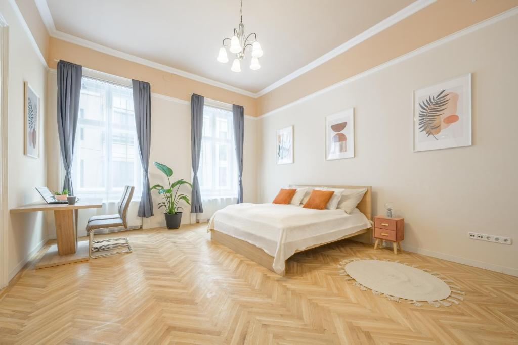 1 dormitorio blanco con 1 cama, mesa y sillas en Best Seasons Andrássy, en Budapest