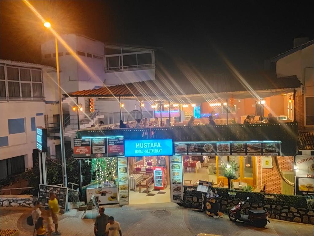 パムッカレにあるムスタファ ホテルの夜間外に人が立つ建物