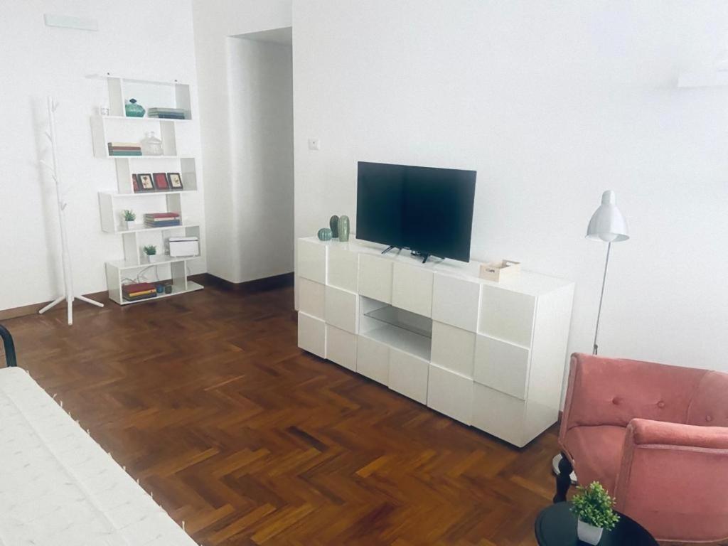 a living room with a television on a white cabinet at Casa Futura in Rome