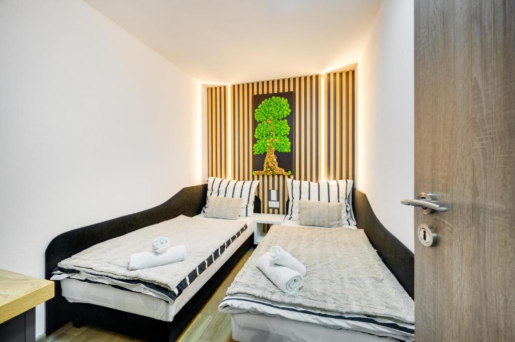2 letti in una camera con un albero sul muro di Milan&Eva a Svätý Jur