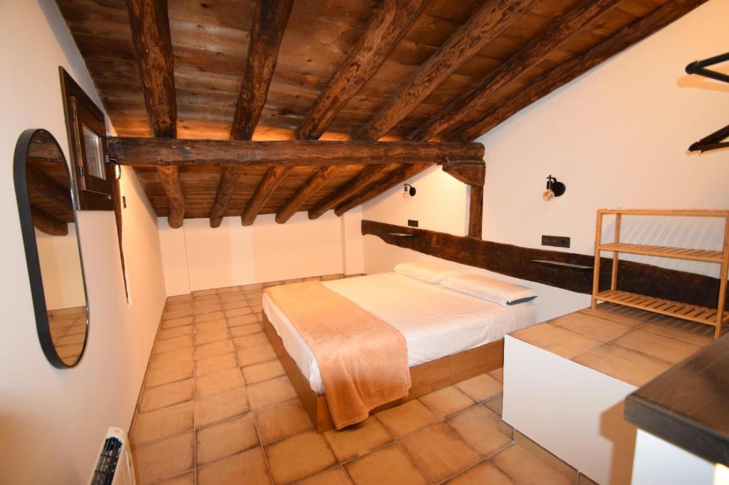 1 dormitorio con 1 cama en una habitación con techos de madera en La Botica, en Albarracín