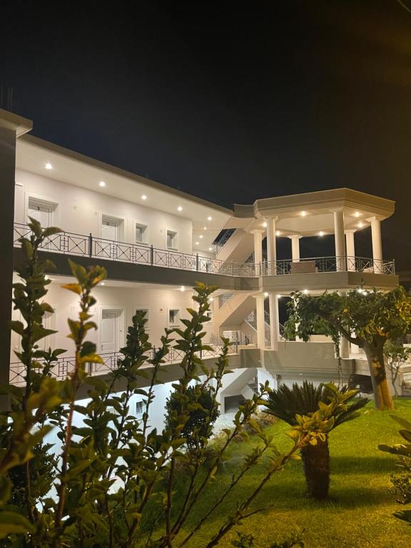 um grande edifício branco com uma varanda à noite em Staikos em Ligia