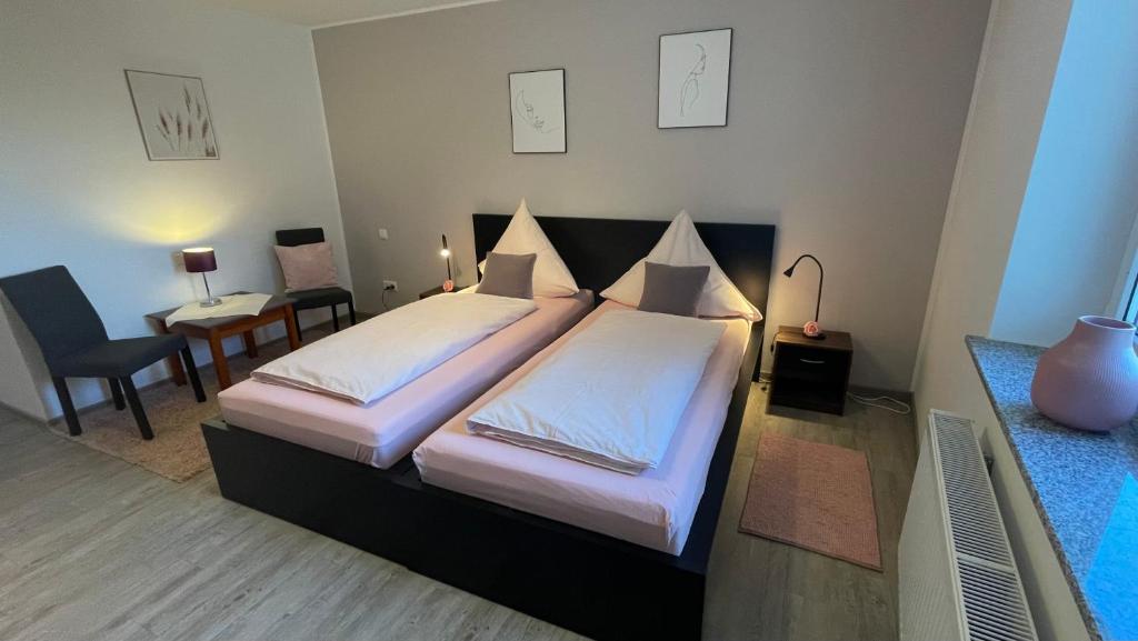 Un dormitorio con 2 camas y un escritorio con una mesa Sidx Sidx Sidx Sidx Sidx. en Spatzennester-Vogelsberger Hof, en Grebenhain