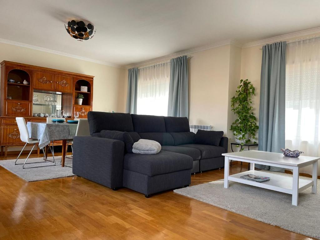 uma sala de estar com um sofá azul e uma mesa em Holiday Flat Green Coast em Espinho