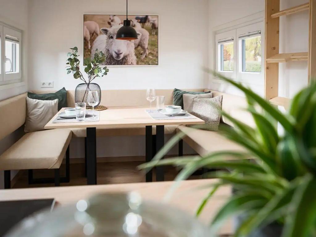 a dining room with a table with a cow picture on the wall at Tiny Om Ferienhaus in Laichingen