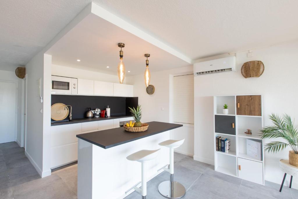 a kitchen with white cabinets and a black counter top at Baie Nettle Beach Villa 1130 in Saint Martin