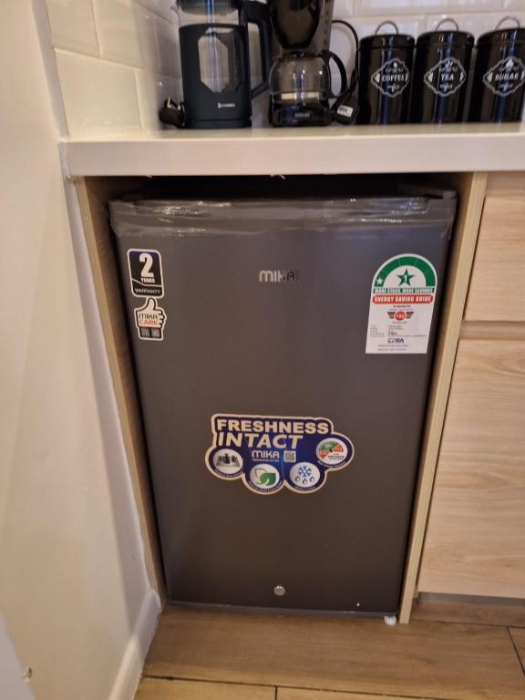 ein Kühlschrank in einer Küche mit Aufklebern in der Unterkunft Avana in Nairobi