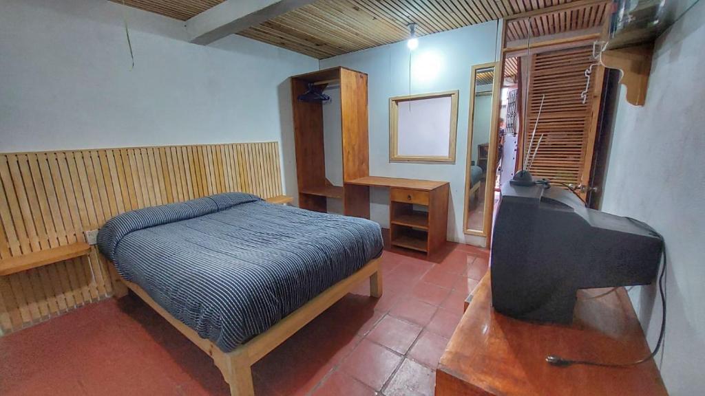 Schlafzimmer mit einem Bett und einem Flachbild-TV in der Unterkunft Loft con excelente ubicación en Valle de Bravo in Valle de Bravo