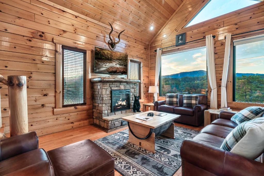 a living room with a fireplace and leather furniture at Epic Mountain Views, Hot Tub, Game Room, Sleeps 10 in Sevierville