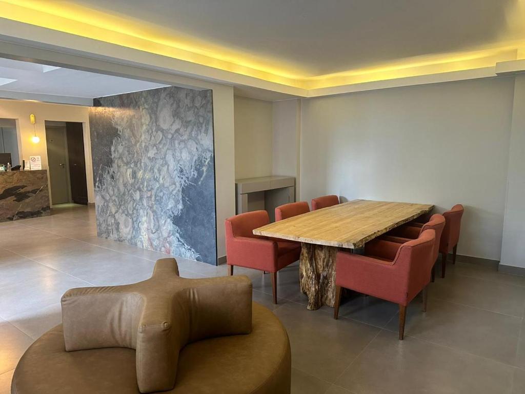 une salle de conférence avec une table en bois et des chaises rouges dans l'établissement Hotel Farol da Ilha, à Florianópolis