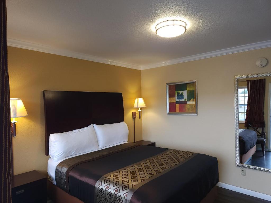 a hotel room with a bed and a lamp at Galaxie Motel in Philomath