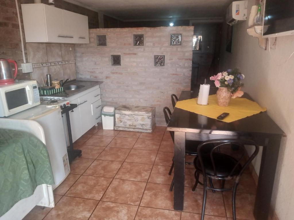 a small kitchen with a table and a microwave at Lo de Guille in Oberá