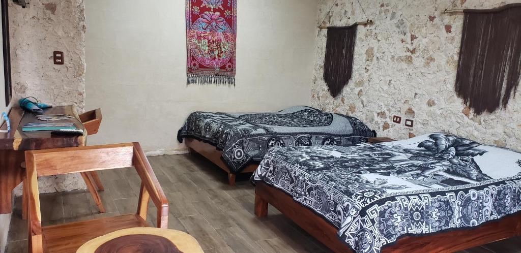 a room with two beds and a table and a chair at Casa los Jarochos in Valladolid