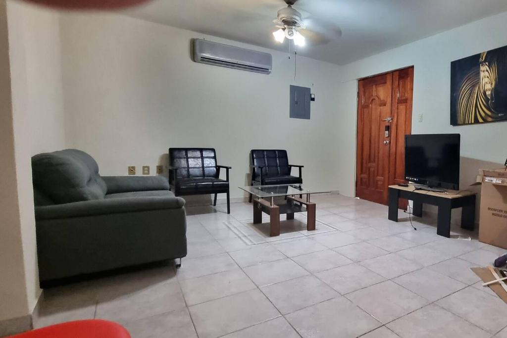 a living room with a couch and chairs and a tv at Departamento Planta Baja para 6 in Tampico