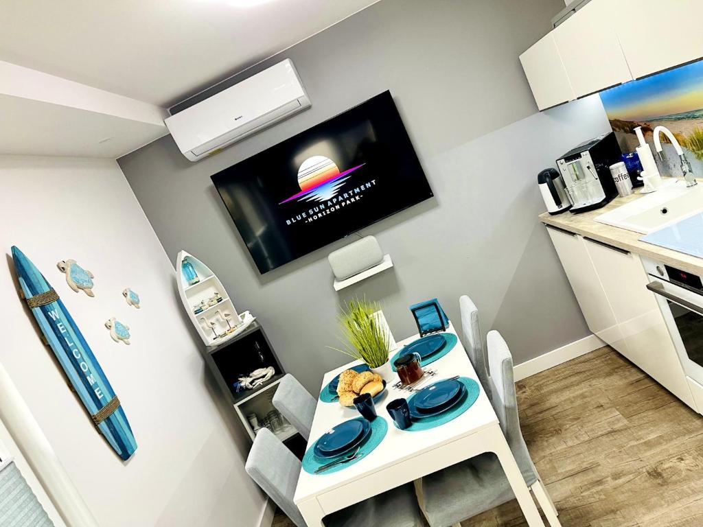 a small kitchen with a table with a tv on the wall at "Blue Sun" Apartament 11B HorizonPark Dziwnòwek in Dziwnówek