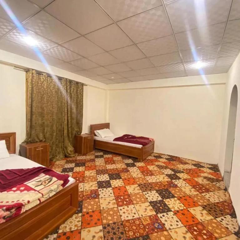 a bedroom with two beds and a quilt at Finger Peak Hotel in Kalām