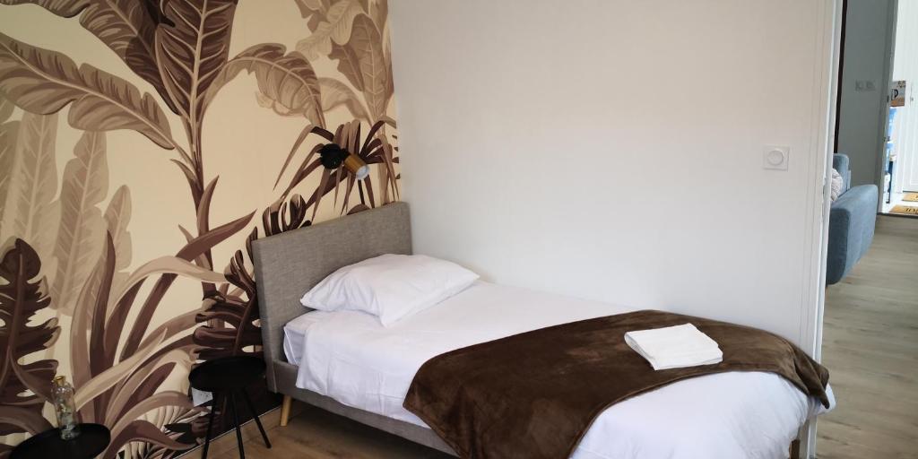 - une chambre avec un lit et un papier peint floral dans l'établissement La chute des feuilles - Bundle - Hyper centre, à Abbeville