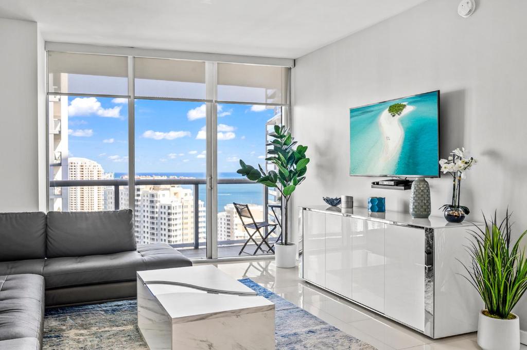 マイアミにある*ICONIC W ICON CONDO/ POOL&WATERVIEWS*FREESPA*のソファと大きな窓のあるリビングルーム