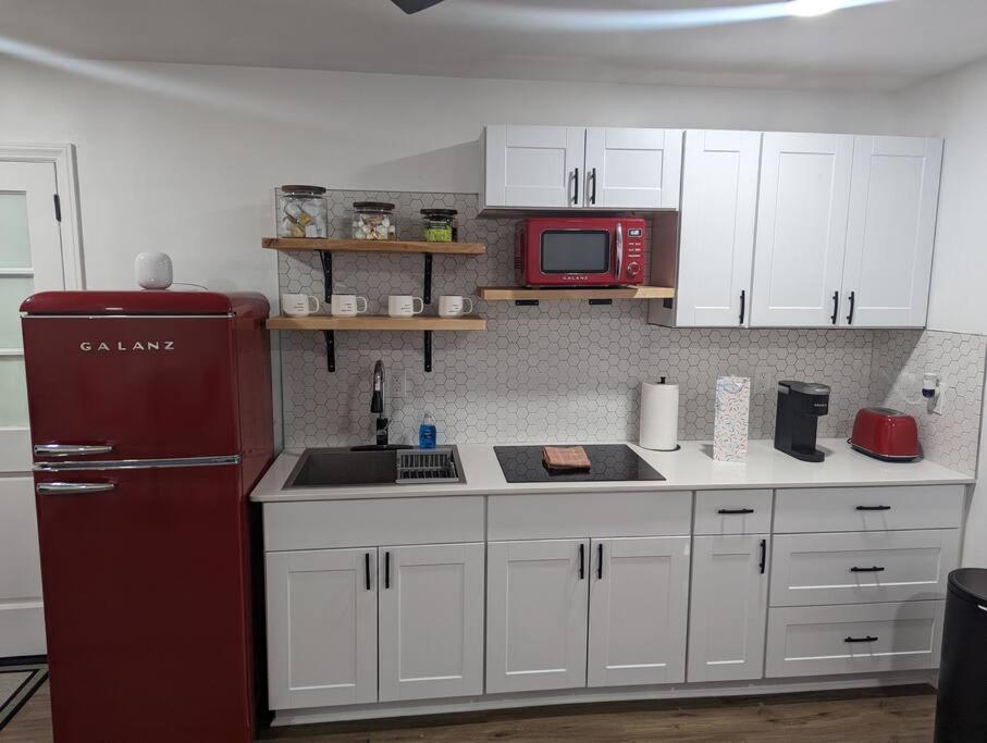 a kitchen with a red refrigerator and white cabinets at Newly Renovated Studio - Close to WakeMed Raleigh in Raleigh