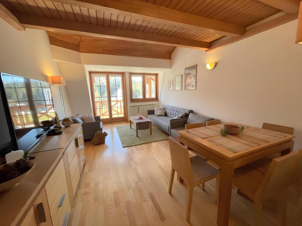 Il comprend une cuisine et un salon avec une table en bois. dans l'établissement Aparthotel Vučko 413 Nina, à Jahorina